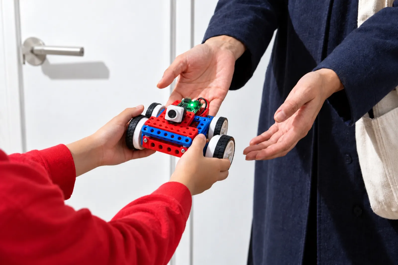 授業のあと、子どもがつくったロボットを保護者の手に渡すところ（写真は見本）